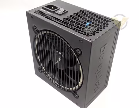 A black computer power supply unit with ventilation grates and a visible fan.