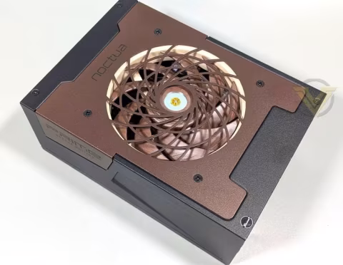 A rectangular power supply unit with a visible fan, featuring Noctua branding and bronze and black metallic finishes.