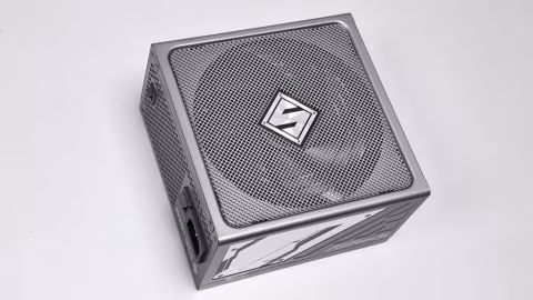 A silver and black computer power supply unit (PSU) with a mesh front panel.