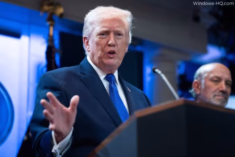 Donald Trump stands at a podium delivering a speech, with another man visible in the background.