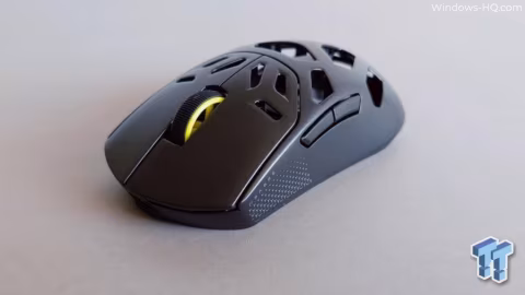 A black wireless gaming mouse with honeycomb vents rests on a plain surface.