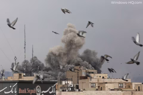 Smoke plume rises over urban buildings with multiple birds flying overhead.