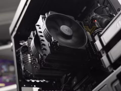 A large black air cooler attached to a computer motherboard in a black computer case.