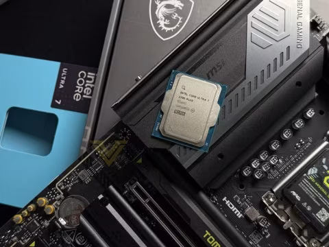 Close-up view of an Intel Core Ultra 7 processor placed atop a motherboard with graphics cards and boxed components.