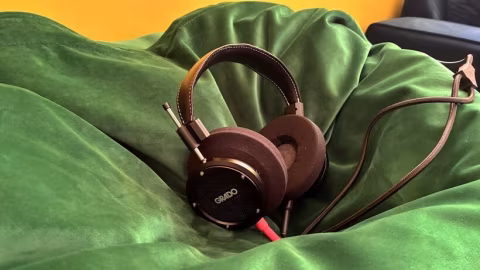 Over-ear headphones rest on a green fabric surface.