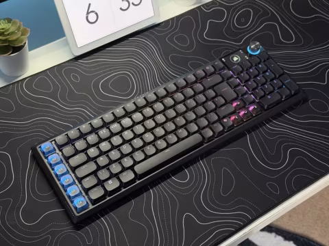 Mechanical keyboard with customizable RGB lighting resting on a desk with a visible numeric keypad.