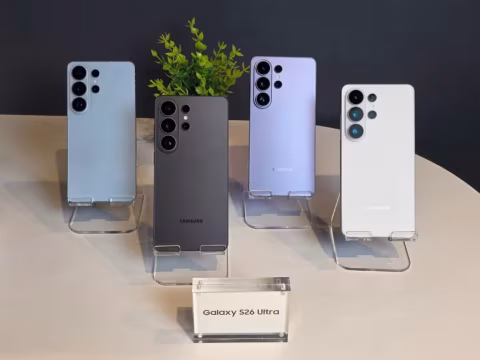 Five colored smartphones are arranged on a table, with a display box in the foreground.