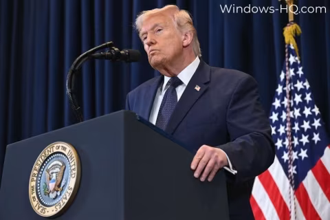 A man in a suit speaks at a podium with the seal of the President of the United States visible.