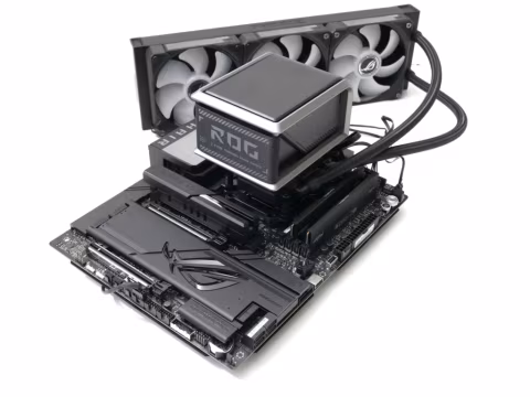 Computer motherboard and cooler components laid out on a white surface.