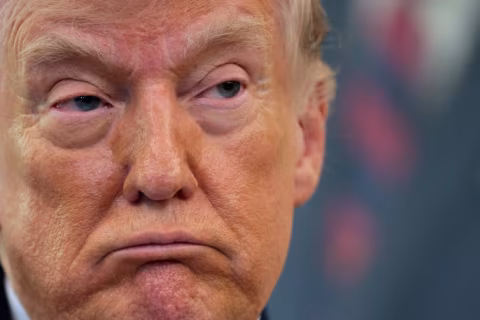 Close-up of a man's face, looking to the side with a serious expression.