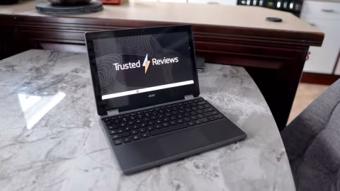 Acer Chromebook open on a marble countertop, displaying a 'Trusted Reviews' screen.