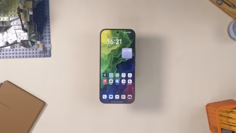 A smartphone displaying the time 16:21 and various app icons on a white background.
