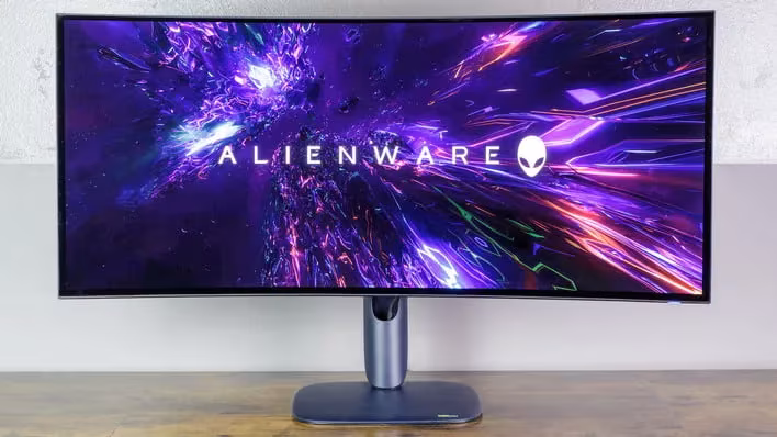 Large ultrawide monitor displaying a glowing abstract pattern with "ALIENWARE" logo visible.