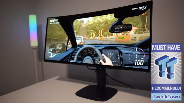 Curved computer monitor displaying a simulated vehicle dashboard interface with digital gauges and metrics.
