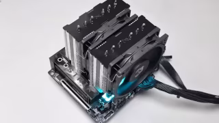 A large black dual-tower CPU cooler heatsink featuring multiple fins and two attached fans, displayed on white.
