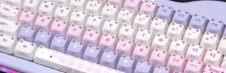 A mechanical keyboard with pink and white keycaps showing standard alphanumeric and modifier keys.