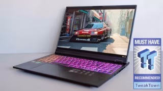 Open laptop displaying an urban street scene graphic on its screen, resting on a surface with purple-marked keys.