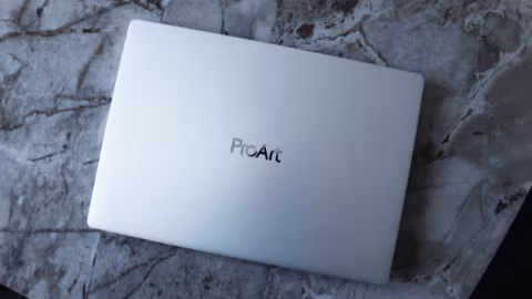 A light-colored laptop closed on a marbled surface, featuring the ProArt logo on the lid.